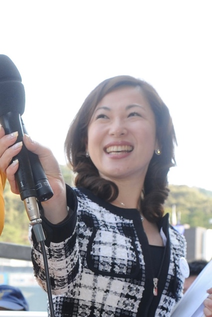 2011年、マイクを持ち笑顔で取材する津田三七子