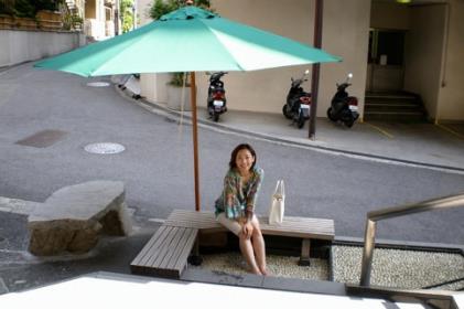 2009年、道後温泉の足湯でパラソルの下に腰かける津田三七子